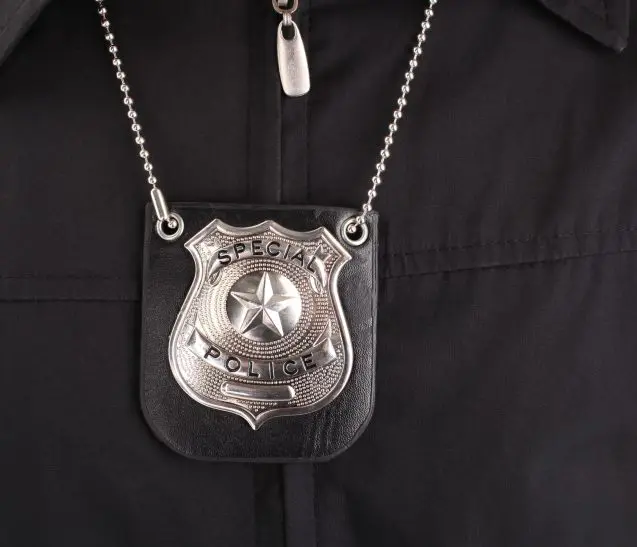 Frame 1618874302 (1) (3) Special police badge on a black uniform.