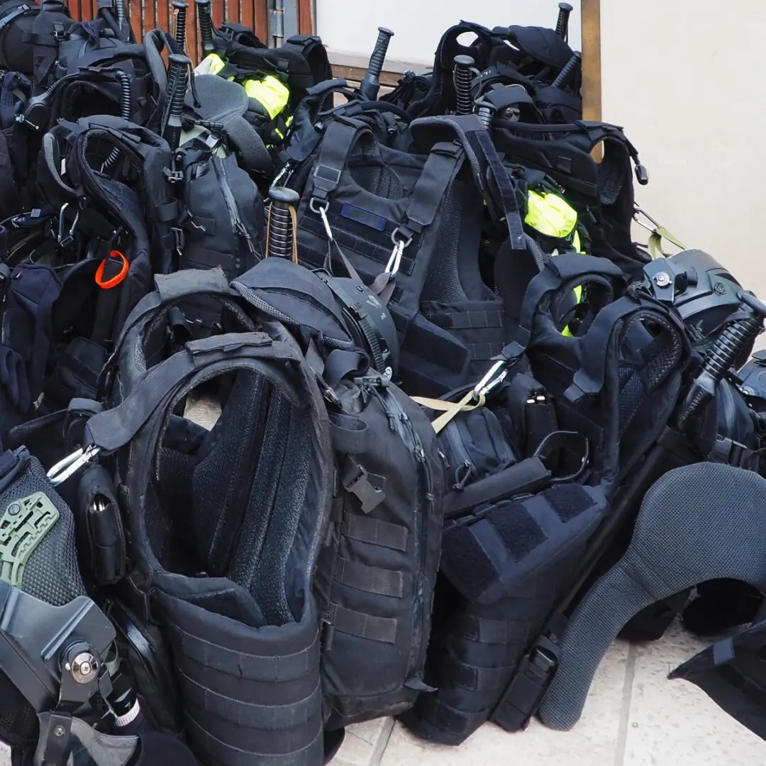 Tactical vests and gear in a pile.