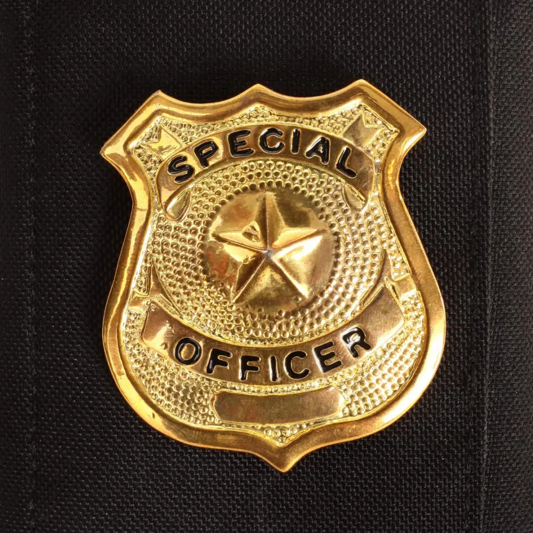 Special officer badge on black fabric background.